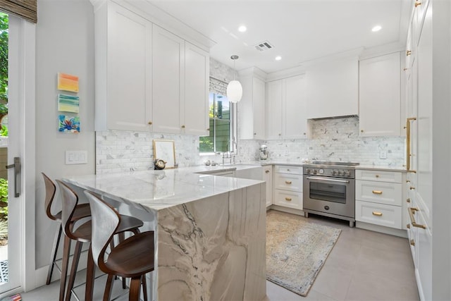 kitchen with white cabinetry, decorative light fixtures, stainless steel range, kitchen peninsula, and light stone countertops