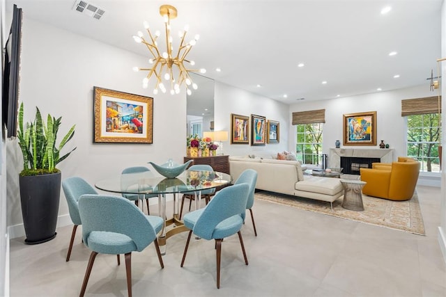 dining space with an inviting chandelier and a fireplace