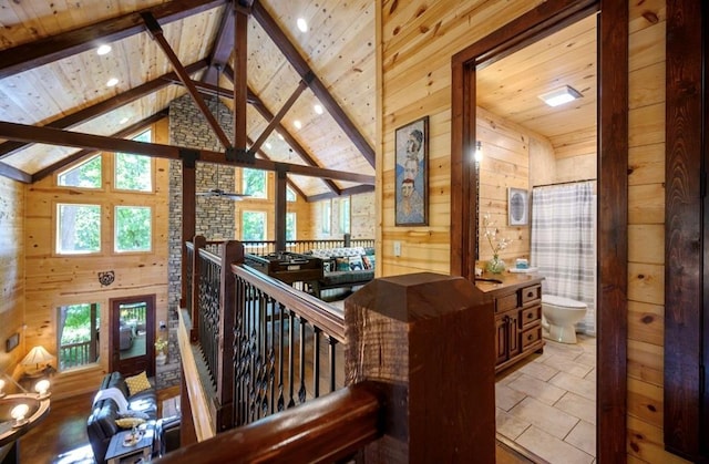 interior space with beamed ceiling, wooden ceiling, high vaulted ceiling, and wood walls