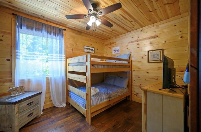 bedroom with ceiling fan, dark wood-type flooring, wood ceiling, and wood walls