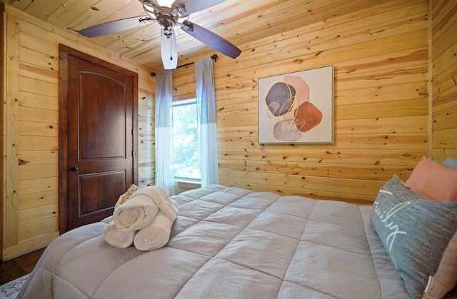 bedroom with wooden ceiling, light hardwood / wood-style floors, ceiling fan, and wood walls