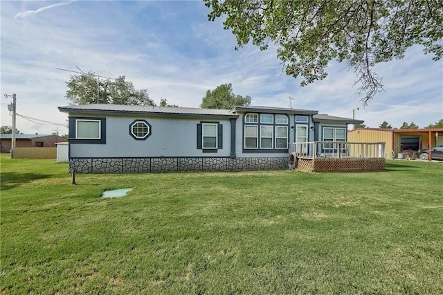 back of house featuring a deck and a lawn