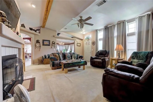 carpeted living room with ceiling fan, vaulted ceiling with beams, and a fireplace