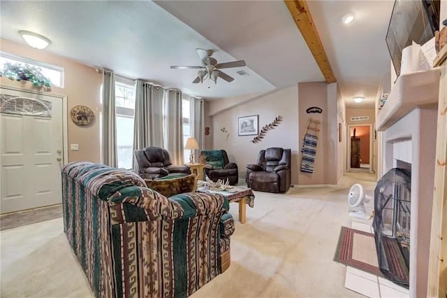 carpeted living room with ceiling fan and beam ceiling