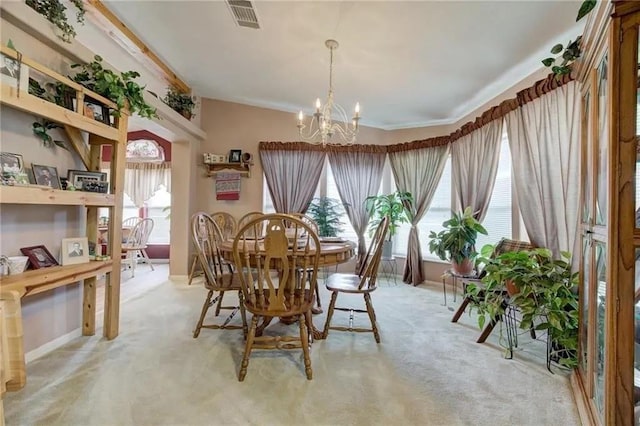 carpeted dining room featuring ornamental molding and a chandelier