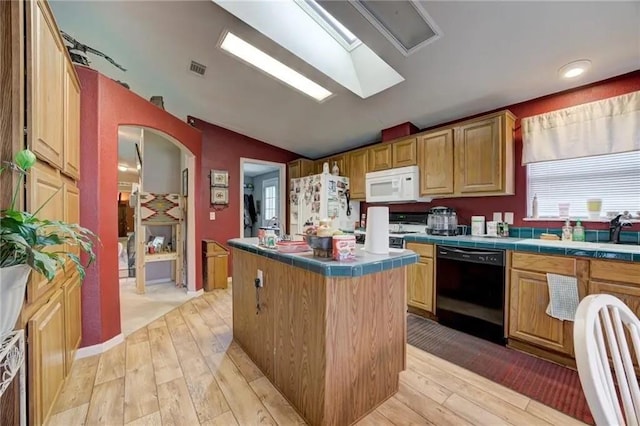 kitchen featuring a kitchen island, lofted ceiling, sink, tile counters, and white appliances