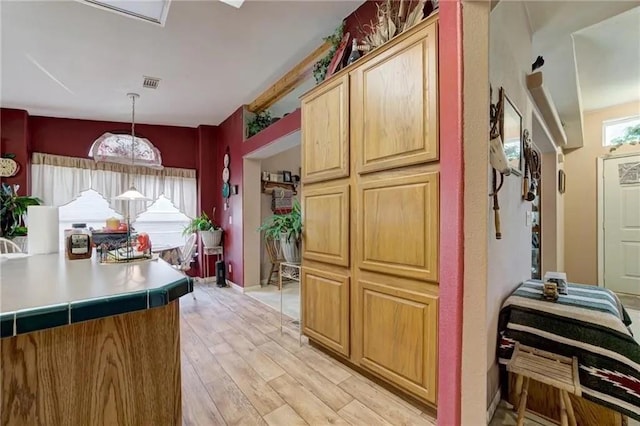 kitchen with hanging light fixtures and light wood-type flooring