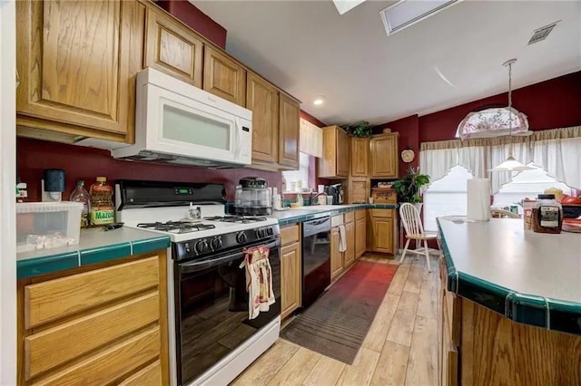 kitchen featuring hanging light fixtures, white appliances, and light hardwood / wood-style flooring