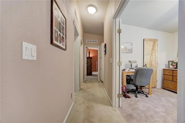 hallway featuring lofted ceiling and light carpet