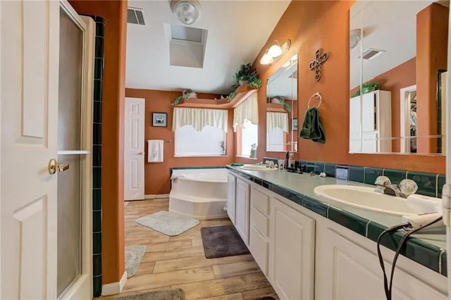 bathroom with vanity, hardwood / wood-style floors, and independent shower and bath