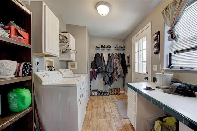 laundry area with cabinets, light hardwood / wood-style floors, and washer and dryer