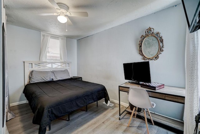 bedroom featuring a textured ceiling, wood-type flooring, and ceiling fan