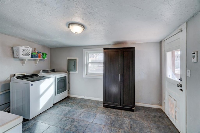 laundry area featuring electric panel, washing machine and dryer, and a textured ceiling