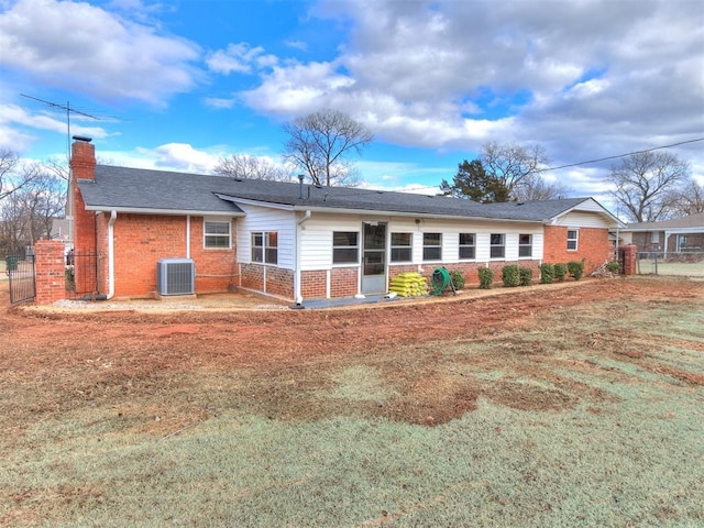 view of front of property with central AC unit and a front lawn