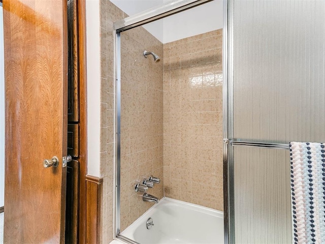 bathroom featuring bath / shower combo with glass door