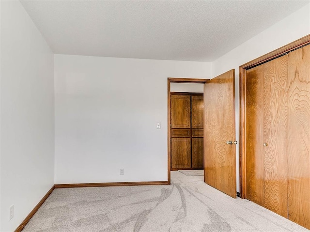 unfurnished bedroom with light colored carpet and a closet