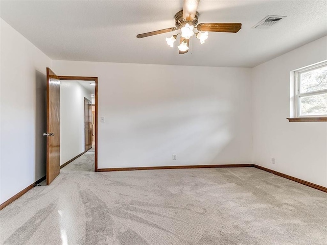 spare room featuring ceiling fan and light colored carpet