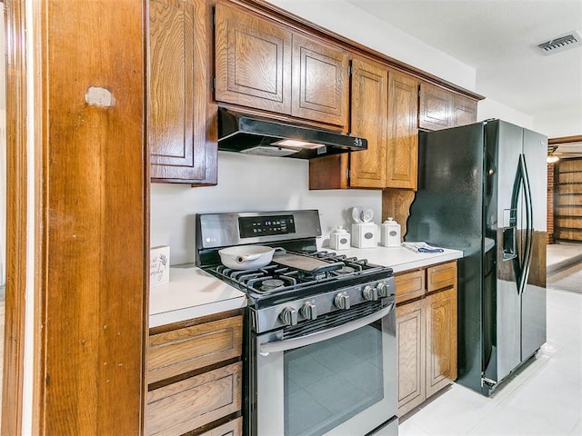 kitchen featuring stainless steel range with gas stovetop and black fridge with ice dispenser