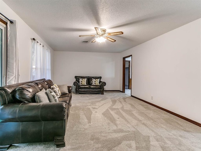 carpeted living room featuring ceiling fan and a textured ceiling