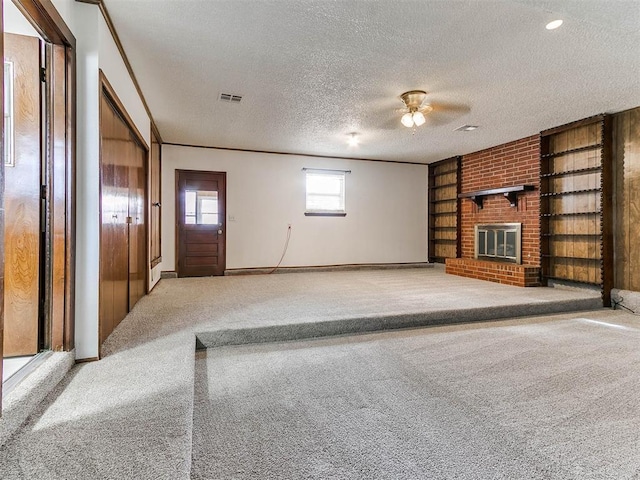 unfurnished living room with light carpet, a brick fireplace, crown molding, and a textured ceiling