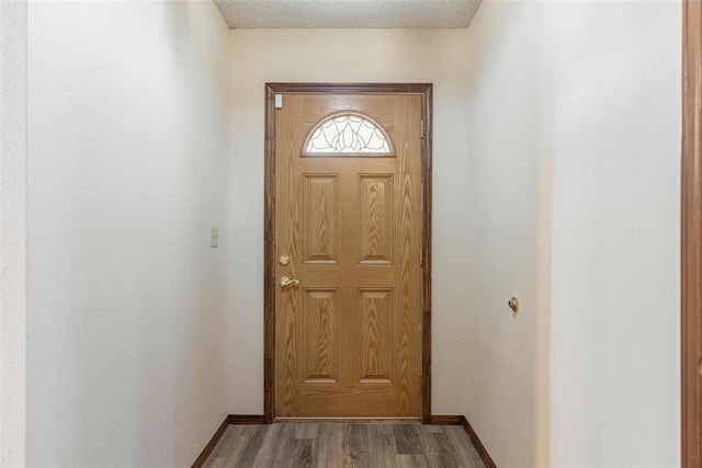 entryway with wood-type flooring and a textured ceiling