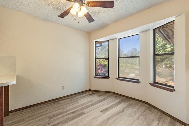 unfurnished room featuring a textured ceiling and light wood-type flooring