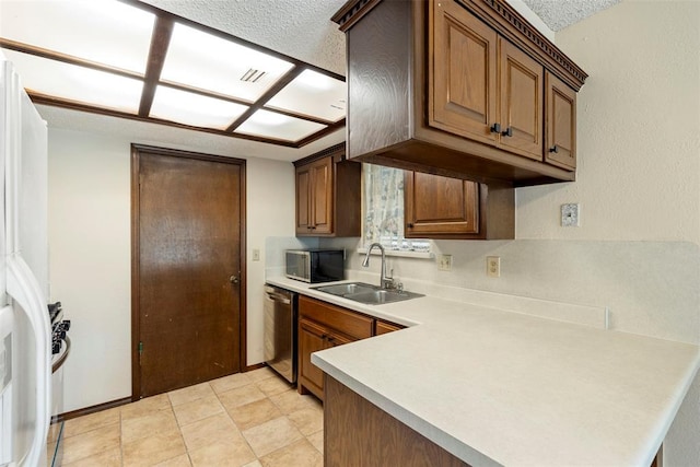 kitchen featuring appliances with stainless steel finishes, sink, a textured ceiling, and kitchen peninsula