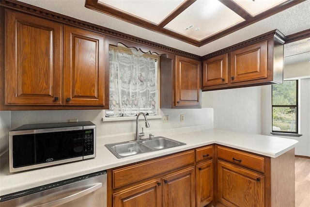 kitchen with appliances with stainless steel finishes, kitchen peninsula, and sink