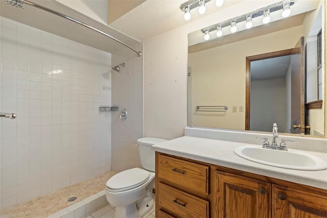 bathroom featuring vanity, toilet, and a tile shower