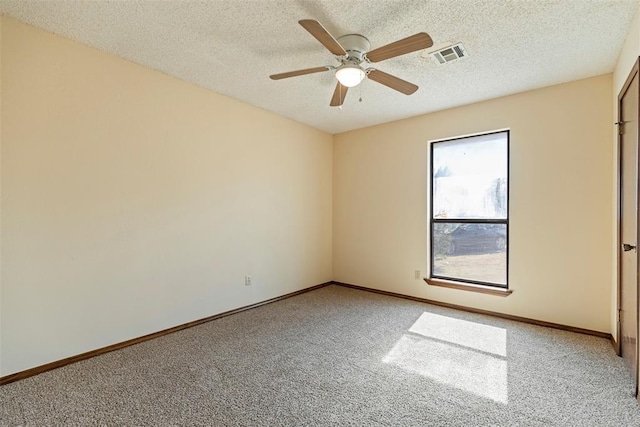 carpeted spare room featuring ceiling fan and a textured ceiling