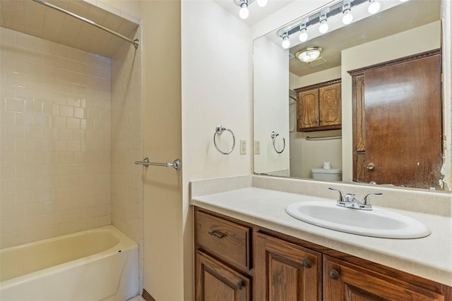 full bathroom with tiled shower / bath combo, vanity, and toilet