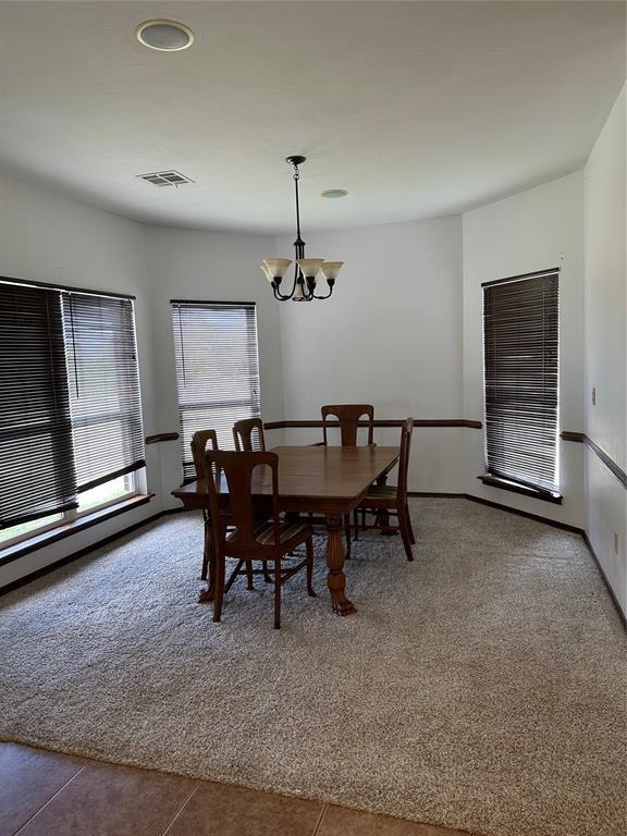 tiled dining space featuring a chandelier