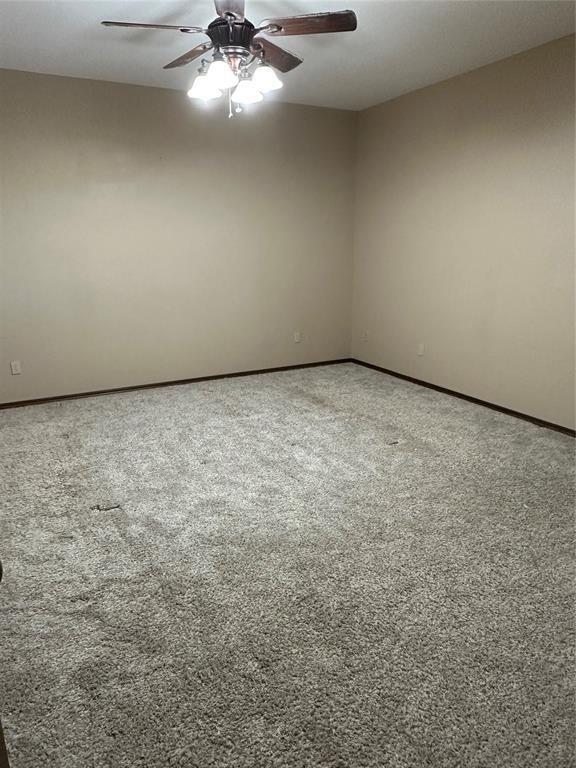 spare room featuring carpet floors and ceiling fan