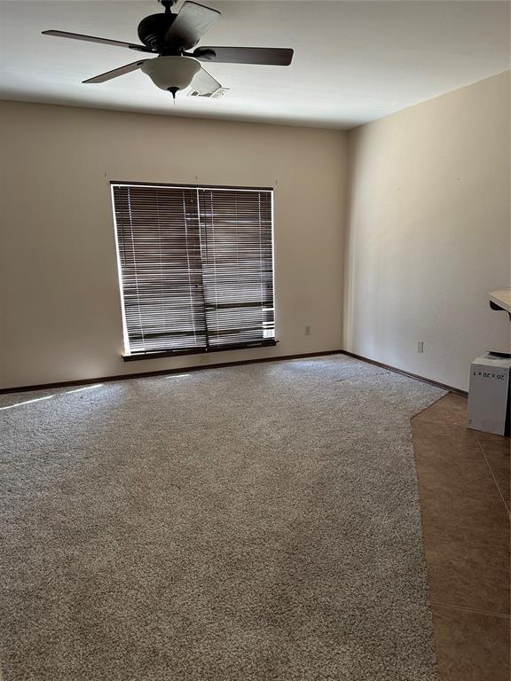 carpeted empty room with ceiling fan