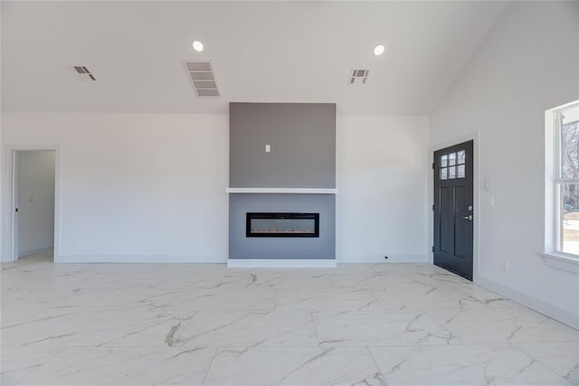 unfurnished living room with high vaulted ceiling and built in features