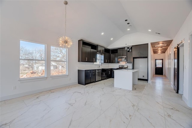 kitchen featuring a kitchen island, high vaulted ceiling, decorative light fixtures, stainless steel appliances, and an inviting chandelier