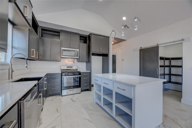 kitchen with lofted ceiling, sink, stainless steel appliances, a center island, and a barn door