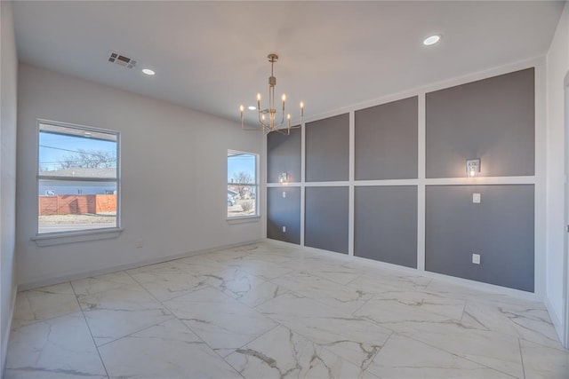 spare room featuring a notable chandelier