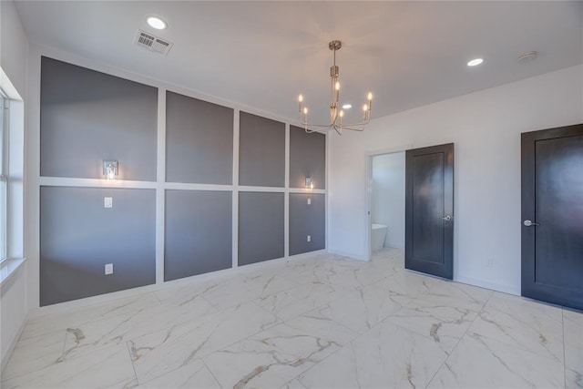 unfurnished bedroom with ensuite bathroom and a chandelier