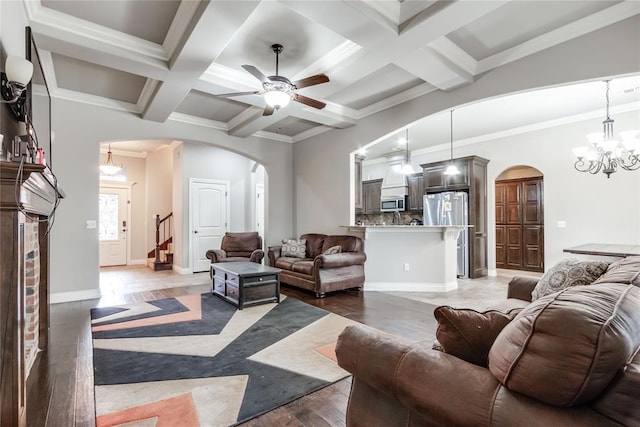 living room with dark hardwood / wood-style flooring, beam ceiling, ceiling fan with notable chandelier, and coffered ceiling