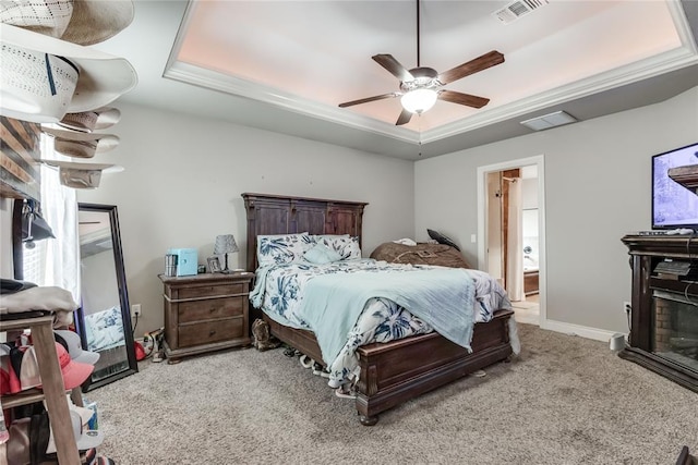 carpeted bedroom featuring crown molding, a tray ceiling, and ceiling fan