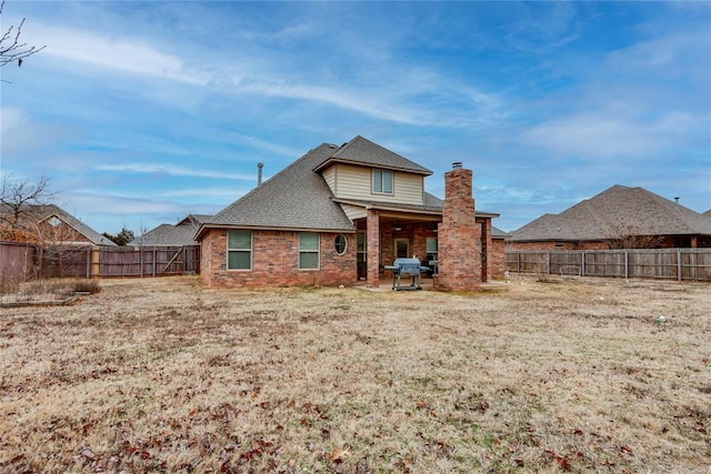 rear view of property featuring a lawn