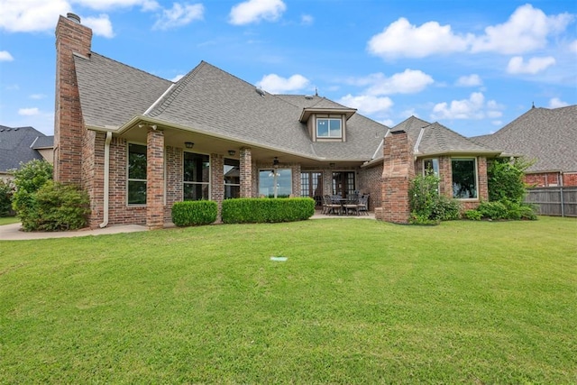 view of front facade with a patio area, ceiling fan, and a front lawn