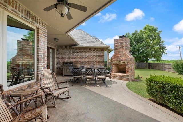 view of patio featuring an outdoor brick fireplace and ceiling fan