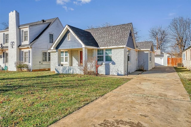 view of front of house featuring a garage, an outbuilding, and a front yard