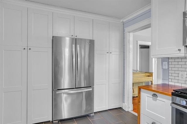 kitchen with backsplash, wood counters, stainless steel appliances, and white cabinets