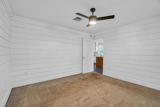 carpeted spare room featuring ceiling fan