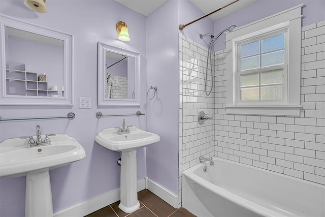 bathroom with tile patterned floors, tiled shower / bath combo, and sink