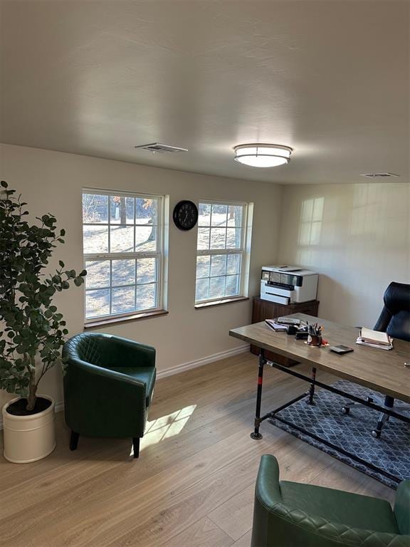 home office with light hardwood / wood-style flooring