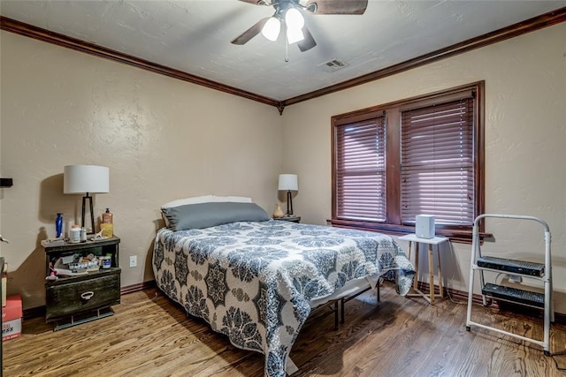 bedroom featuring crown molding, ceiling fan, and wood-type flooring